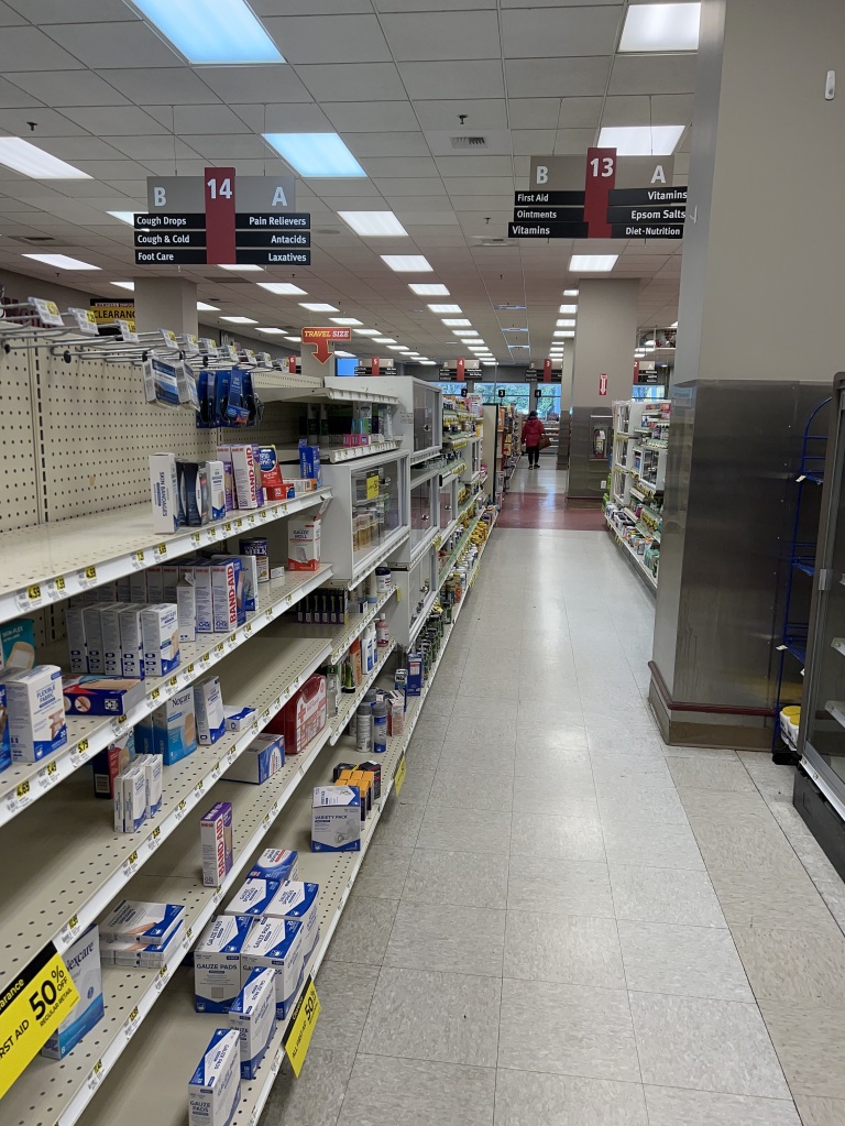 Interior of store shelves, half empty, inside Bartell Drugs. 